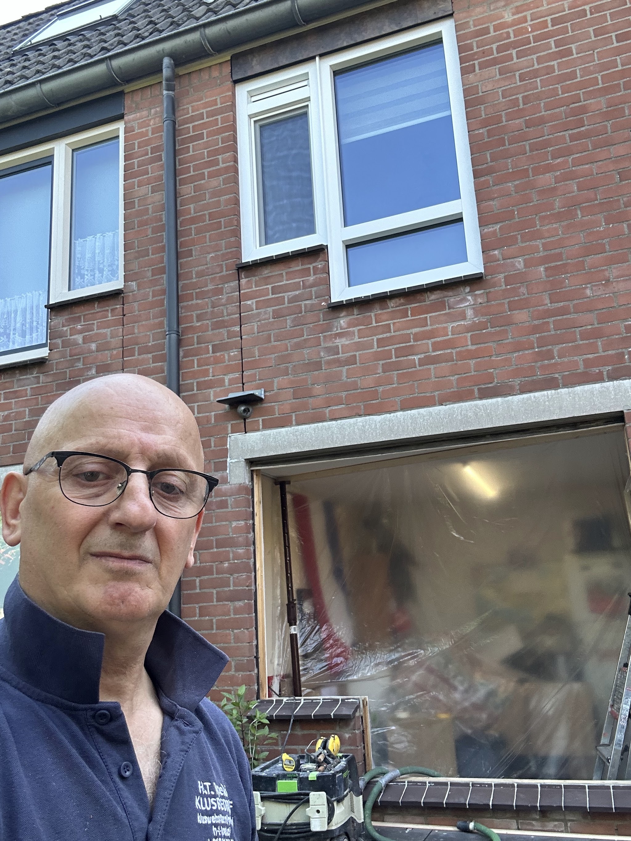 Temel Ipekçi in zijn werkpolo voor een woning waar een kozijn wordt vervangen